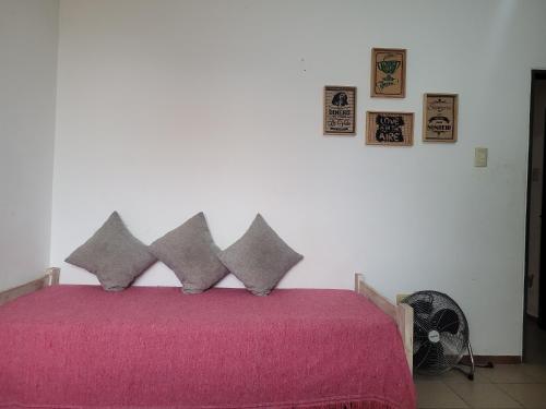 a bedroom with a pink bed with four pillows at Depto Céntrico II in Corrientes