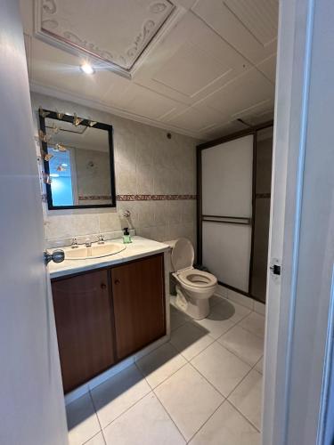 a bathroom with a toilet and a sink and a mirror at Way Maker sede 2 in Bogotá