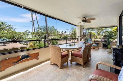 a patio with a table and chairs and a large window at Direct Oceanview Paradise in a luxury condo 2B2B,AC in Kailua-Kona