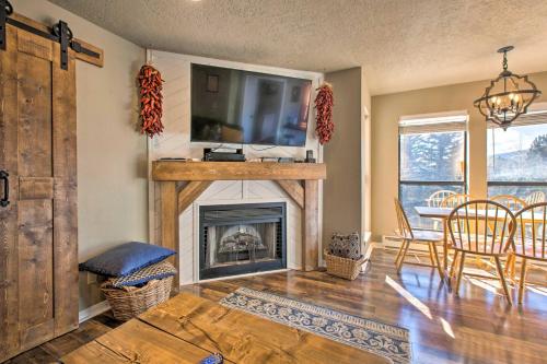 a living room with a fireplace with a flat screen tv at Modern Mountain Retreat with Views Ski, Golf and Hike in Angel Fire