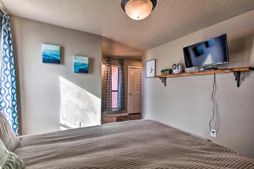 a bedroom with a bed and a flat screen tv at Modern Mountain Retreat with Views Ski, Golf and Hike in Angel Fire