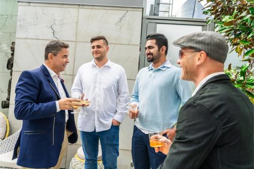 a group of men standing around with drinks at AZUR Legacy Collection Hotel in Vancouver
