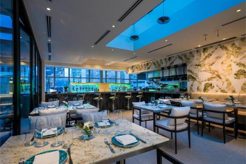 a restaurant with tables and chairs and a bar at AZUR Legacy Collection Hotel in Vancouver