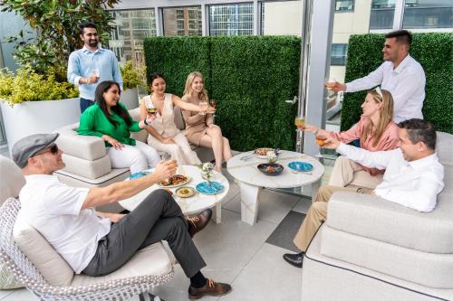 a group of people sitting on a patio drinking wine at AZUR Legacy Collection Hotel in Vancouver