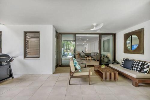 una sala de estar con un sofá y una mesa en Fresco Tropical: Private Pool Haven by Golf Course, en Port Douglas