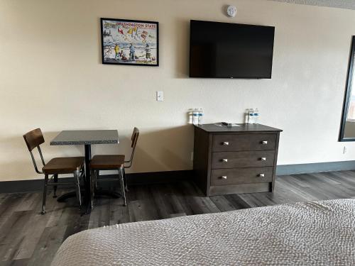 a hotel room with a table and a television on the wall at Inn at the Sea in Long Beach