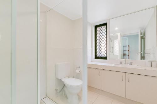 ゴールドコーストにあるTugun By The Beach Unit 1のトイレと鏡のある白いバスルーム