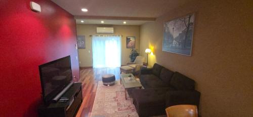 a living room with a couch and a flat screen tv at Vibrant Living in Harmony, unit C in Seattle