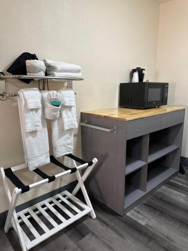 a room with a desk with a microwave and a chair at Inn at the Sea in Long Beach