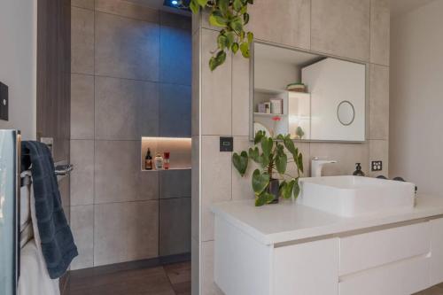 a bathroom with a white sink and a shower at Expansive Luxury Country Escape in Prebbleton