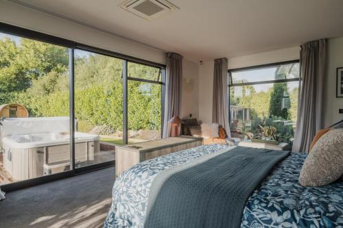 a bedroom with a bed and a bath tub next to a window at Expansive Luxury Country Escape in Prebbleton