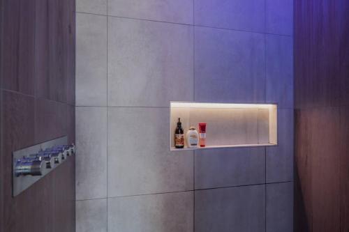 a shower with bottles of alcohol on a wall at Expansive Luxury Country Escape in Prebbleton