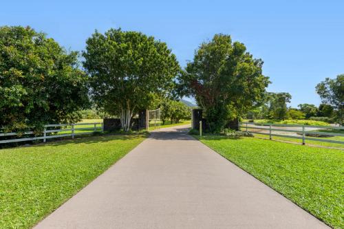 a walkway in a park with trees and grass at The Hampton Lodge with private pool on 25 acres in Port Douglas