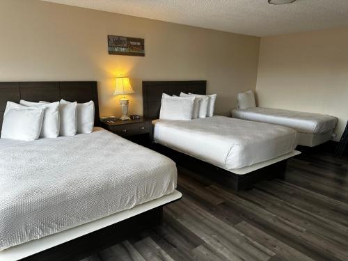 a hotel room with two beds and a lamp at Inn at the Sea in Long Beach