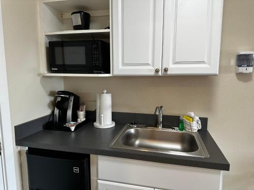 a kitchen with a sink and a microwave at Inn at the Sea in Long Beach