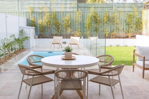 a patio with a table and chairs and a pool at Aster in Narrawallee