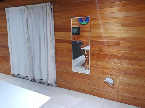 a mirror on a wooden wall in a bathroom at Cabaña Entre Arboles in Tandil