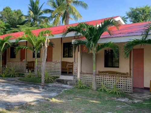a house with palm trees in front of it at palanas white sand beach resort in Himensulan
