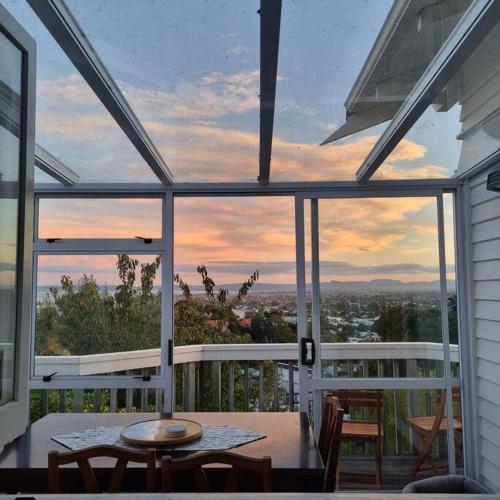 a screened in porch with a table and chairs at Views on the Terrace in Napier