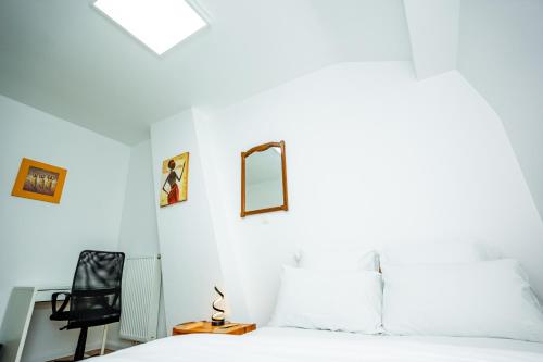 a bedroom with a bed and a mirror on the wall at Chambre R2 avec salle de bain partagée près de l'hôpital de la Citadelle à Liège in Liège
