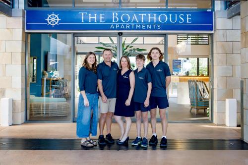 a group of people standing in front of a store at The Boathouse Apartments in Airlie Beach