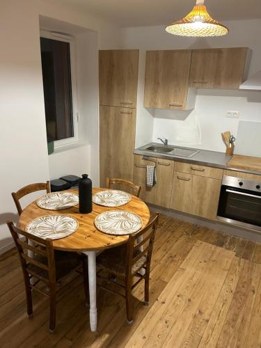 une cuisine avec une table en bois et des chaises ainsi qu'une salle à manger dans l'établissement Maisonnette Saint Marcel Le petit Pitolat, à Saint-Marcel