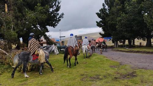 a group of people riding horses down a road at Ruta de los volcanes in Machachi