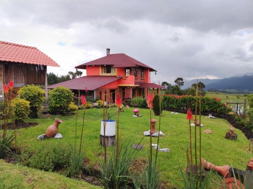 a house with a yard with flowers in front of it at Ruta de los volcanes in Machachi