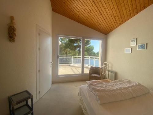 une chambre avec un lit et une grande fenêtre dans l'établissement Villa Proche Plage avec Jardin, Terrasse et WiFi – La Tranche-sur-Mer - FR-1-22-272, à La Tranche-sur-Mer