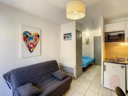 un salon avec un canapé et une cuisine dans l'établissement Charmant Studio à Lamalou, 400m du Centre, Balcon, Wifi, Animaux Bienvenus - FR-1-451-137, à Lamalou-les-Bains