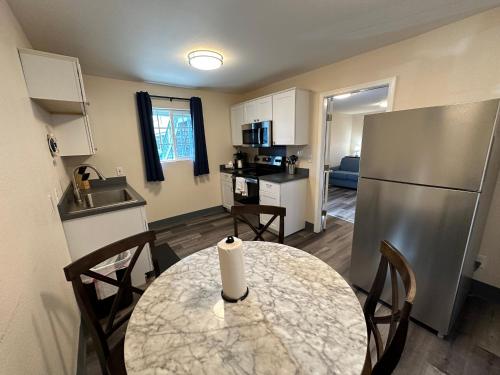 a small kitchen with a table and a refrigerator at Coastal Inn and Suites in Long Beach