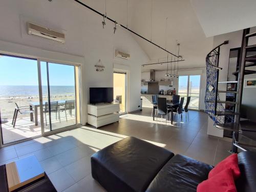 un salon avec un canapé et une vue sur l'océan dans l'établissement Châtelaillon-Plage: Appartement 4 pièces, 6 pers, terrasse, WIFI - FR-1-706-11, à Châtelaillon-Plage