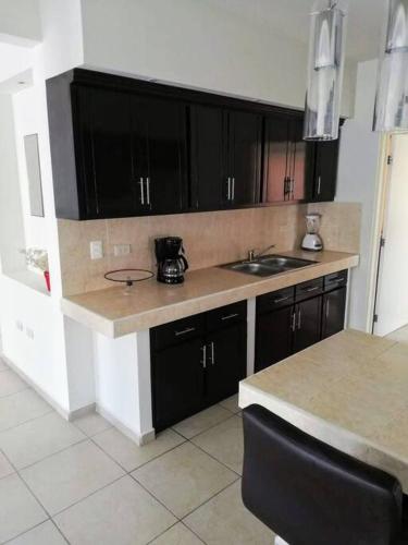 a kitchen with black cabinets and a counter top at Amplia residencia con acceso privado in La Paz