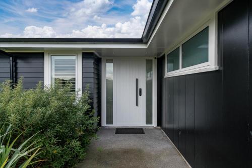 a black and white house with a white door at Oasis on Okaia in Kinloch