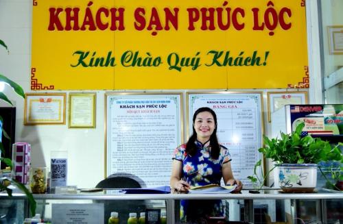 a woman standing behind a counter in a restaurant at Phúc Lộc Hotel Ninh Bình in Ninh Binh