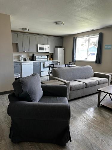 a living room with two couches and a kitchen at Coastal Inn and Suites in Long Beach