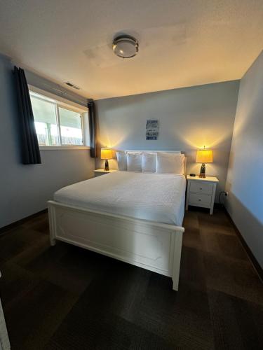 a bedroom with a white bed with two lamps at Coastal Inn and Suites in Long Beach