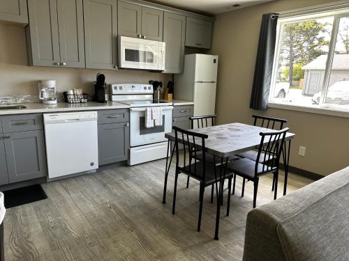 a kitchen with a table and chairs and a kitchen with white appliances at Coastal Inn and Suites in Long Beach