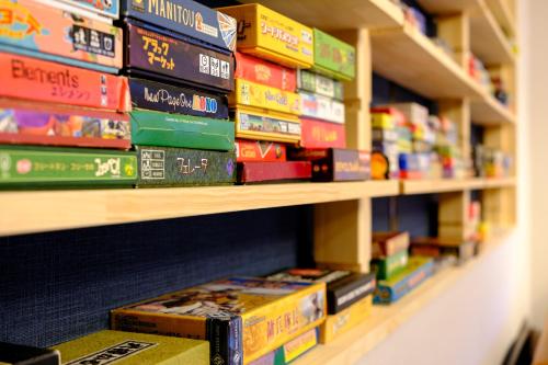 ein Stapel Bücher auf einem Regal in einer Buchhandlung in der Unterkunft Board Game House Tokyo in Tokio