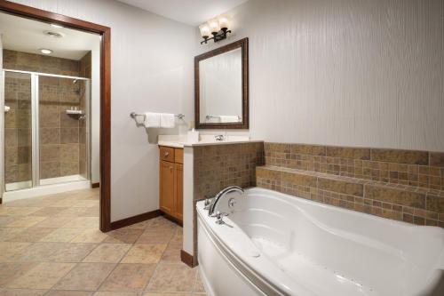 a large bathroom with a tub and a mirror at Club Wyndham Glacier Canyon in Lake Delton