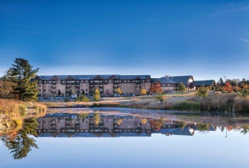 a view of a hotel from across a lake at Club Wyndham Glacier Canyon in Lake Delton