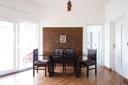 a dining room with a black table and chairs at Shiphouse in Alleppey
