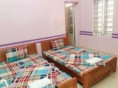 two twin beds in a room with at Cat Ba Mystery Homestay in Cat Ba