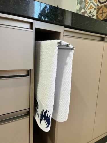 a pair of towels hanging on a cabinet in a kitchen at Apê aconchego in Brusque