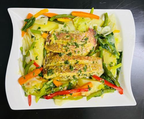 a white plate of food with fish and vegetables at TRMOTEL in Matola