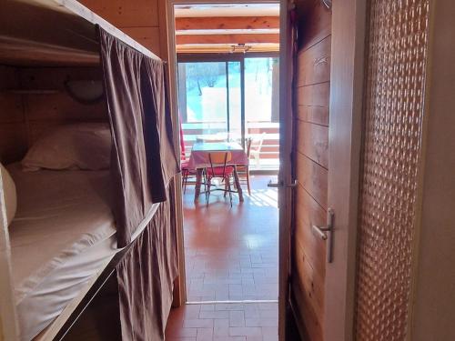 Cette chambre comprend des lits superposés et une table avec des chaises. dans l'établissement Appartement T2 pour 6 pers avec terrasse plein sud et cuisine équipée, face aux pistes - FR-1-165A-192, à Enchastrayes