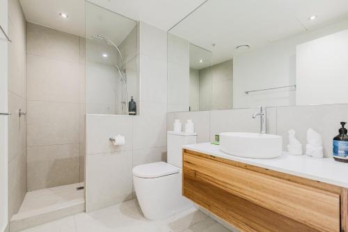 a bathroom with a sink and a toilet and a shower at Easy Eastside - Urban Chic with a Rooftop Pool Oasis in Melbourne