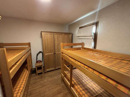 Cette chambre comprend deux lits superposés et un réfrigérateur. dans l'établissement Auris en Oisans: Appart 4 pers, 250m pistes, balcon, parking gratuit, animaux admis - FR-1-297-339, à Auris