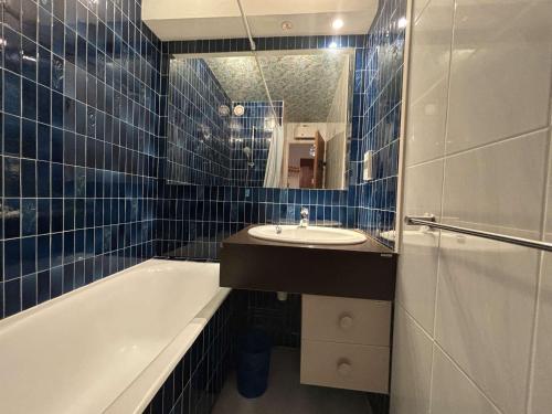 une salle de bain avec un lavabo, une baignoire et un miroir dans l'établissement Auris en Oisans: Appart 4 pers, 250m pistes, balcon, parking gratuit, animaux admis - FR-1-297-339, à Auris