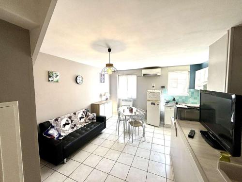 un salon avec un canapé et une cuisine dans l'établissement Maison rénovée, 2 chambres, climatisée, parking, animaux acceptés, Port-la-Nouvelle - FR-1-229C-101, à Port-la-Nouvelle